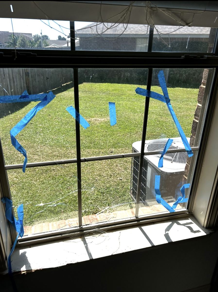 Before: broken window glass held together with blue tape